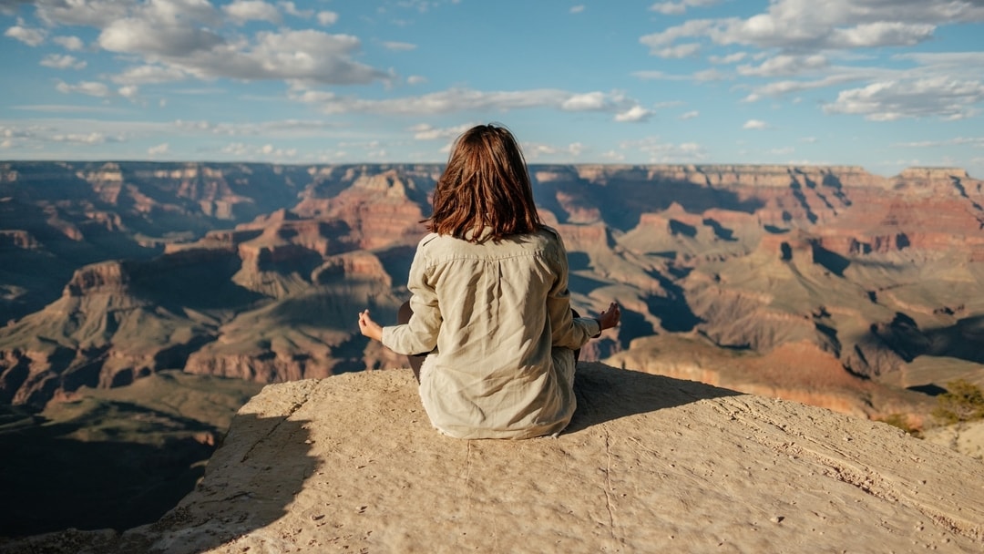 Woman meditating on the rim of the Grand Canyon, Arizona