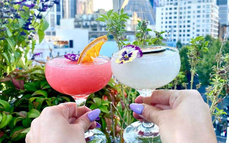 People holding and posing cocktails for image.