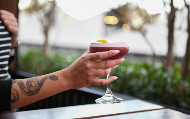 Image with person posing with a cocktail at the Albion Rooftop Bar.