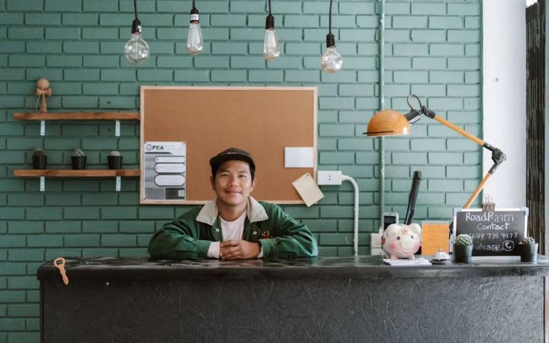 Image of smiling man at counter of RoadRann Skate House Hostel.