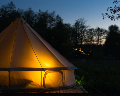 Canvas glamping tent glows at night