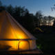 Canvas glamping tent glows at night