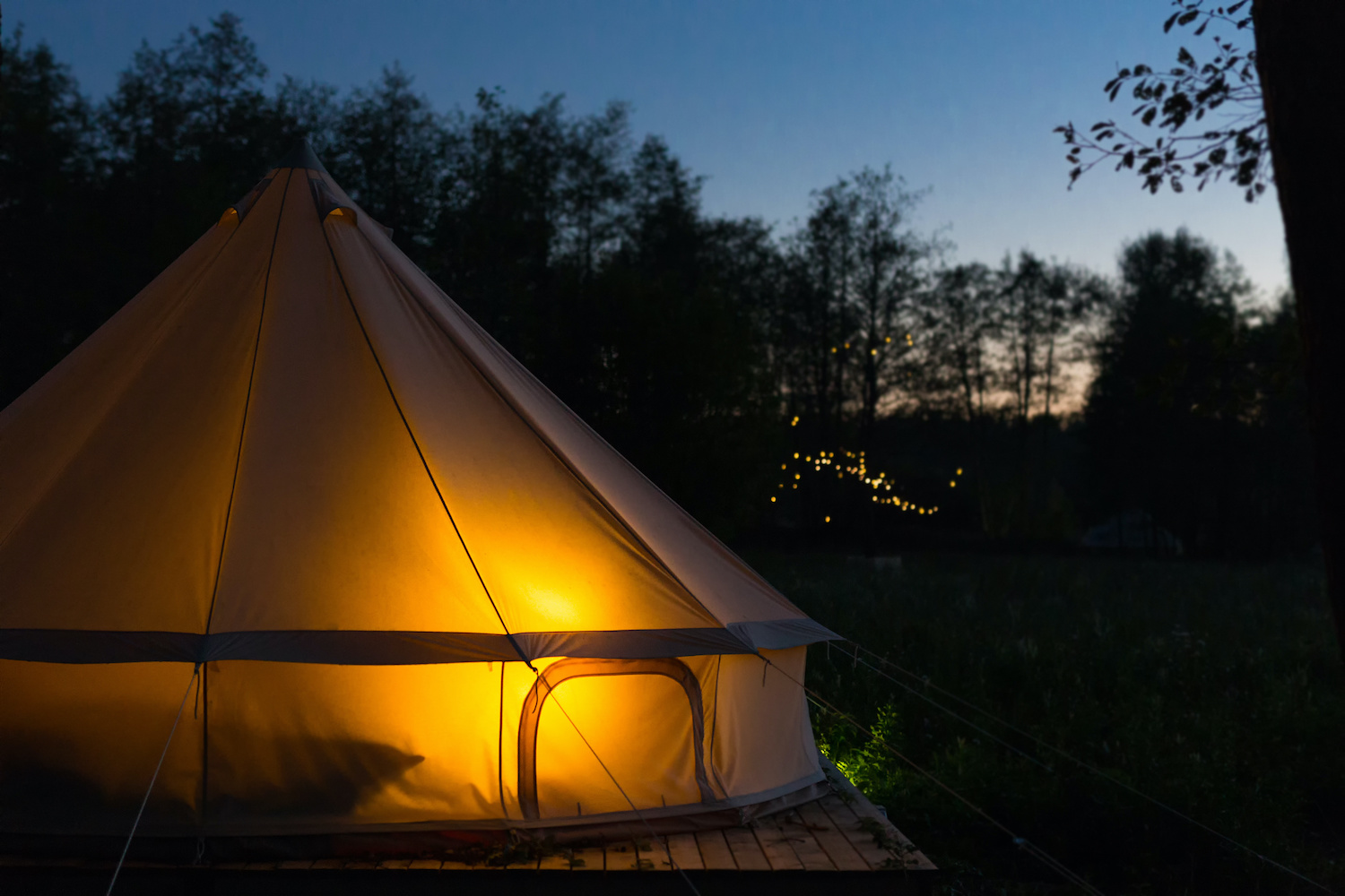 Canvas glamping tent glows at night