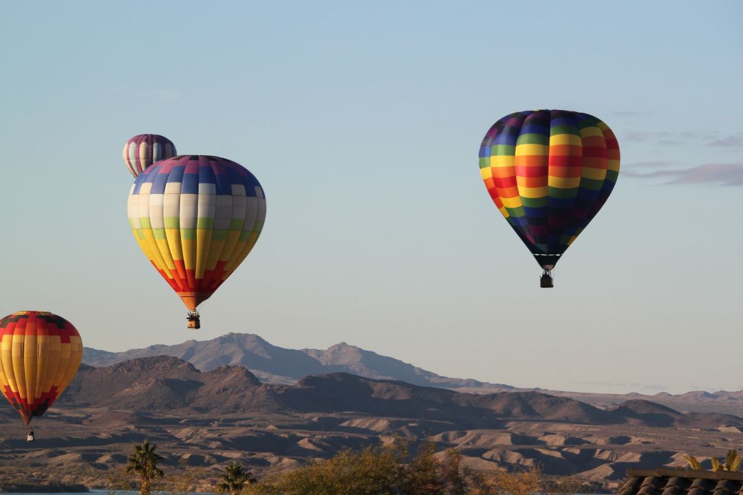 Hot air balloons floating over the desert