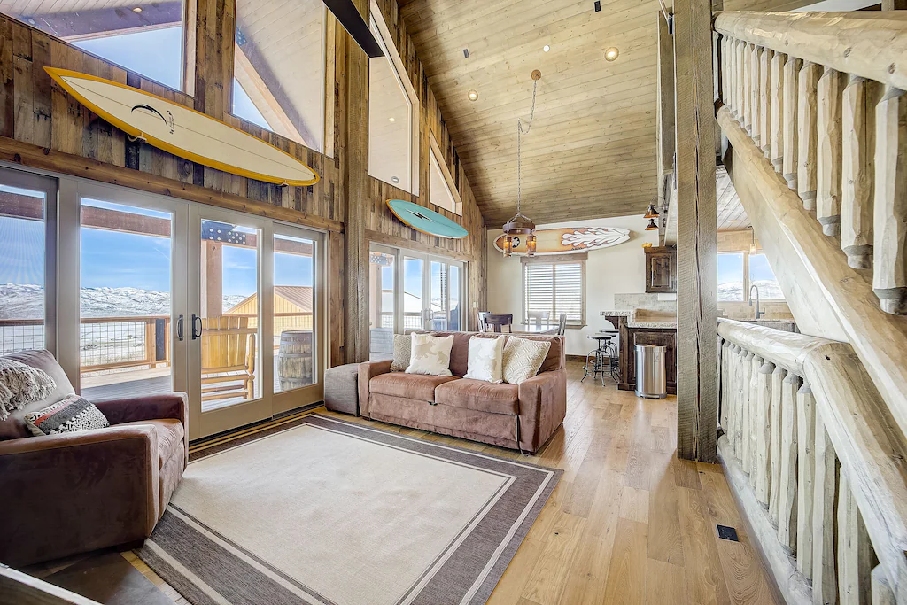 Wide windows inside a luxury cabin show the mountains