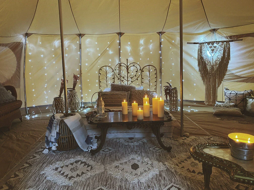 Candles and a bed inside the glamping home