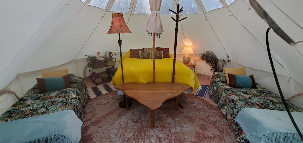 Inside of a tipi with a bed