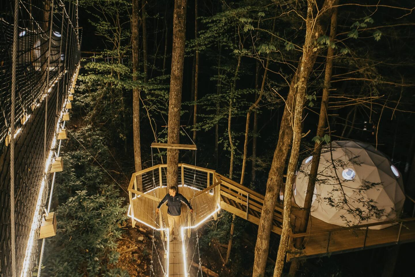 Man walking on a wooden platform to the glamping site